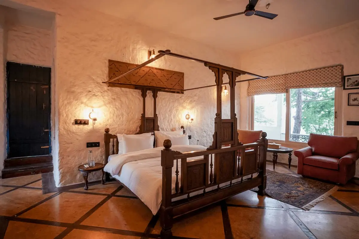 Four-poster bed against whitewashed stone walls in the Deluxe Valley Room, Two Chimneys Gethia
