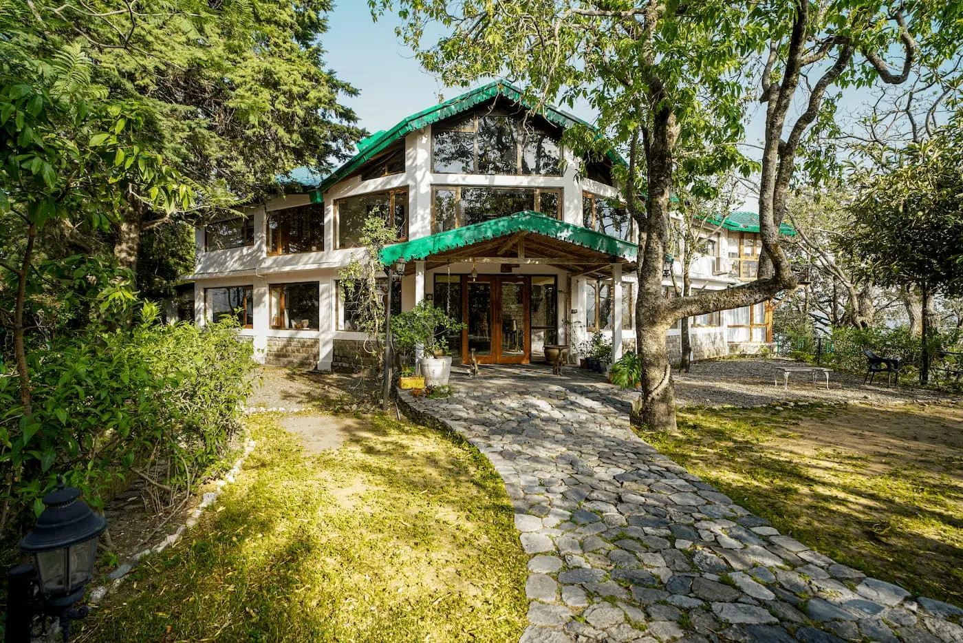 Daytime view of the heritage bungalow and stone pathway at Two Chimneys, Gethia