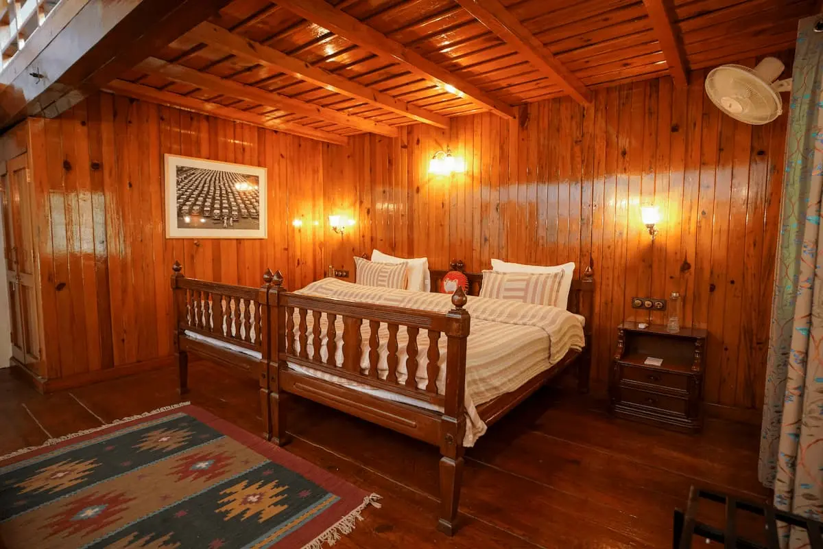 Wood-panelled bedroom with king bed in the Two Chimneys Signature Suite, Gethia